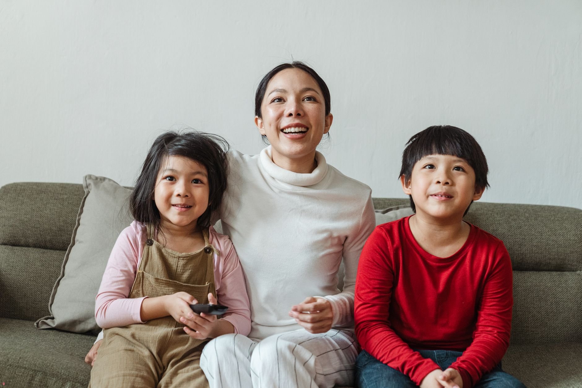 Excited mother and children watching content together on TV